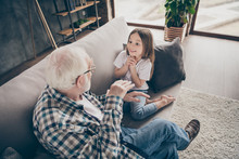 Photo Of Funny Two People Old Grandpa Little Interested Granddaughter Sitting Sofa Telling Good Story Stay House Quarantine Safety Modern Design Interior Living Room Indoors