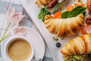 Poster - The concept of a hearty and tasty breakfast of fresh classic croissants with a variety of toppings from ricotta jamon avocado, strawberries, sun-dried tomatoes, and French mustard.