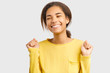 © EverGrump - Girl feels ecstatic, raising fists in celebration, triumph and excitement after hit jackpot. success, concept of victory. happy African-American teenage girl is celebrating victory has an upbeat mood