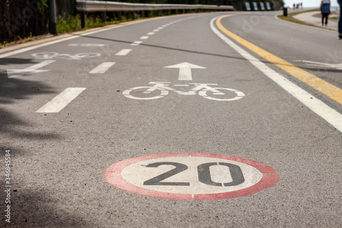 Cuadros en Lienzo bicycle and speed limit signs on asphalt path