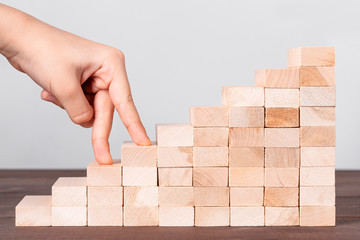 Childs hand climbing stairs from wooden cubes. Way to school success, achieving goals, progress, kids motivation