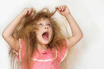 Wall Mural - a little girl with tangled long hair in a pink dress on a white background. a portrait with an open 