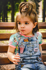 may 2020. kiev ukraine. a little girl plays outside in a park, collects plants on a sunny day in den
