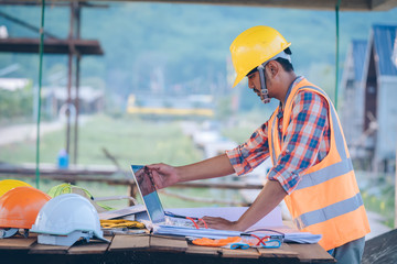 Poster - Engineer working with laptop and blueprints,engineer inspection in construction site for architectural plan,sketching a construction project.