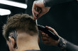 © Aliaksandr Barouski - Male haircut with electric razor. Tattooed Barber makes haircut for client at the barber shop by using hairclipper. Man hairdressing with electric shaver.