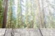 The wooden tables with blurry forest background