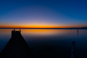 Wall Mural - wooden pier lonely at the sea with beautiful sunset. lsunset seascape at a wooden jetty.