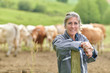 Portrait of a smiling cattlewoman standing beside her cows