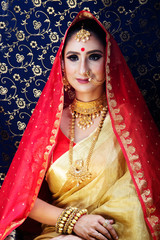 Wall Mural - Indian Bridal wear in a golden and red saree and royal jewellry