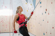 © Westend61 - Woman with a rope securing partner on the wall in climbing gym