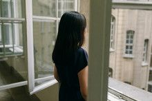 Back View Of Woman Looking Out Of Window