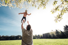 Father Throwing Little Daughter Up In Air