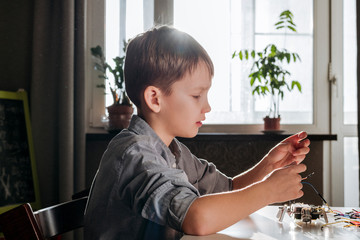 Boy assembling robot at home