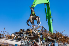 Germany, Baden-Wurttemberg, Stuttgart, Mechanical Claw Over Heap Of Scrap Metal Lying In Junkyard