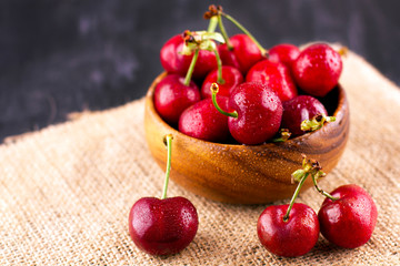 Fresh cherry on black wooden table. Ripe sweet berries in droplets of water