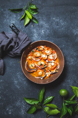 Wall Mural - Scallops on tomato and white wine sauce with lemon, cilantro in pan on dark background. Top view