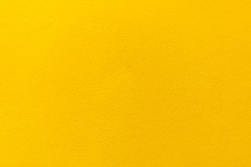 Blurred Yellow stucco wall background. Yellow painted cement wall texture.