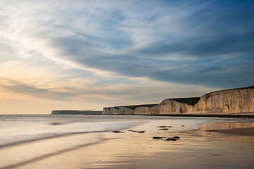 Wall Mural - Stunning landscape image of white chalk cliffs with colorful vibrant sunset on English coast