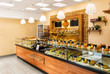 © ArtEvent ET - Baked baguettes and pies on showcase in bakery shop. Inscriptions in russian with the name baking: cheesecake, bun, pie, baguette and others