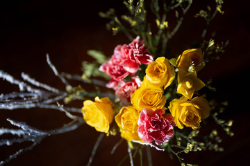 Roses and carnations bouquet on the brown background