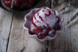 Berry ice cream with a lavender flower and grape decoration in a ceramic bowl on a wooden background. Provence or scandinavian style