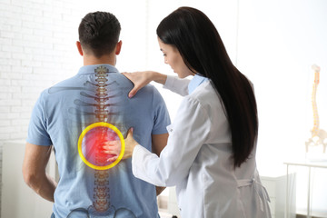 Poster - Professional orthopedist examining man in medical office. Spinal pain