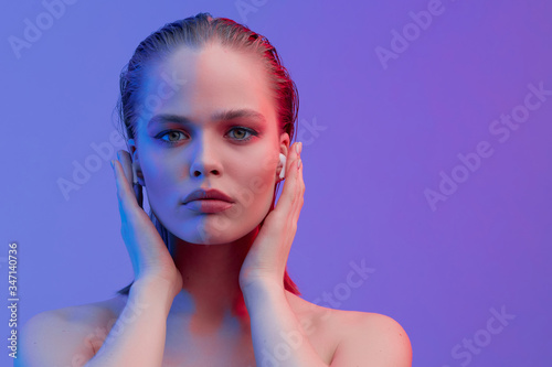 Cuadros en Lienzo A beautiful young girl in wireless headphones listens to song with a good mood