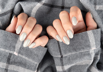 Beautiful womans hand with manicure in checkered shirt