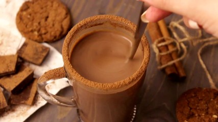 Wall Mural - The close-up video shows a glass cup with thick hot chocolate. Hot chocolate interfere with a spoon