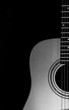 © stockmagen - Acoustic guitar close-up view with a black background. Selective focus. b&w.
