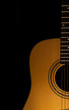 © stockmagen - Acoustic guitar close-up view with a black background. Selective focus. Copy space.