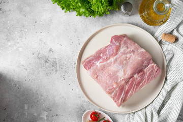 Wall Mural - Raw pork carbonade on a wooden plate on the light gray kitchen table. Raw pork meat, tenderloin. Top view with space for text