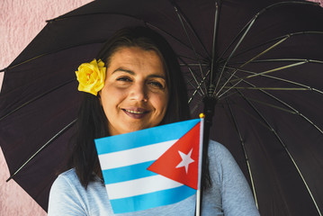 Sticker -  Woman with umbrella holds flag of Cuba in front of isolated wall background