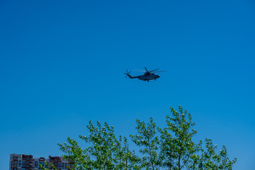 One helicopter of russian air forces is flying in a row on bright blue sky