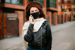 © Катя Іваськевич - young woman with mobile phone in the city in mask. coronavirus. covid-19.