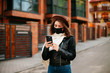 © Катя Іваськевич - young woman with mobile phone in the city in mask. coronavirus. covid-19.
