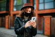 © Катя Іваськевич - young woman with mobile phone in the city in mask. coronavirus. covid-19.