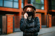 © Катя Іваськевич - young woman with mobile phone in the city in mask. coronavirus. covid-19.