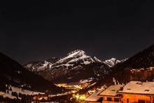Noche Estrellada Con Las Montañas Nevadas Y El Pequeño Pueblo Iluminado. Chatel , Alpes Franceses.
