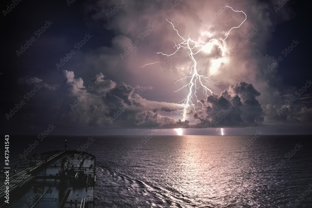 Lightning Over Sea Against Sky - obrazy, fototapety, plakaty 
