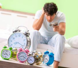 Young man having trouble waking up in early morning