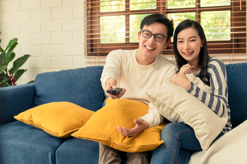 Wall Mural - sweet asian marry couple happiness romantiv enjoy family moment at home wathching tv and enjoy recreation program on couch sofa home interior background