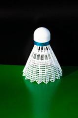 lastic  Badminton shuttlecock. Macro of a plastic  shuttlecock isolated on the green background. Design of a shuttlecock. Badminton accessories. Sports equipment. place for text