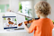 Child playing violin. Remote learning.