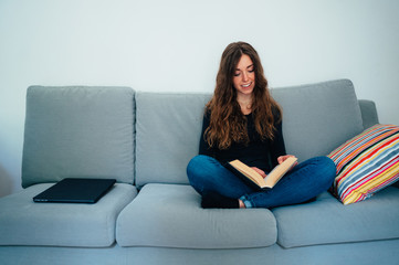 Wall Mural - Giovane ragazza preferisce leggere a casa che utilizzare il computer