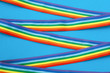 © Yekatseryna - crossed rainbow ribbons and awareness ribbon on a blue background
