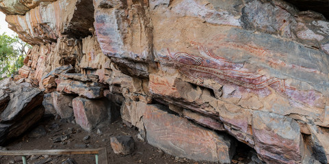 A man views ancient rock paintings in a rock shelter at Nanguluwurr, near Burrunkuy (Nourlangie Rock), Kakadu National Park, Northern Territory, Australia.