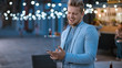 © Gorodenkoff - Handsome Happy Young Man is Using a Smartphone while Standing Outdoors in the Evening. He's Browsing the Internet or Social Media, Posting a Status Update. Man is Wearing a Suit.