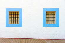 Mediterranean Architecture: Two Blue Windows With A Black Grid On A White Facade In Ibiza, Spain