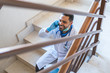 © MCStock - Doctor Talking by Phone at Hospital Stairs on His Work Brake .